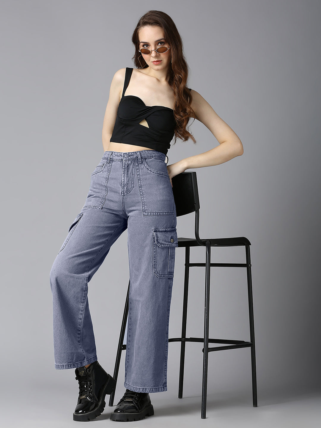 Model styling Cefalu Grey Denim Cargo Pants with a Black Crop Top and Chunky Boots - Edgy Streetwear Outfit