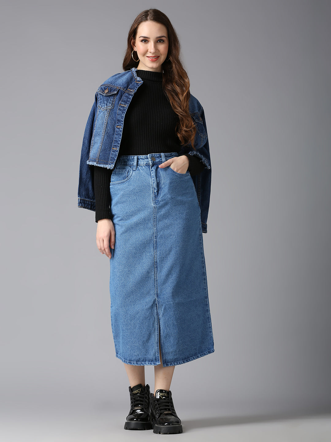 Model styling Cefalu Light Blue Denim Midi Skirt with a Black Sweater & Boots - Trendy Streetwear Look