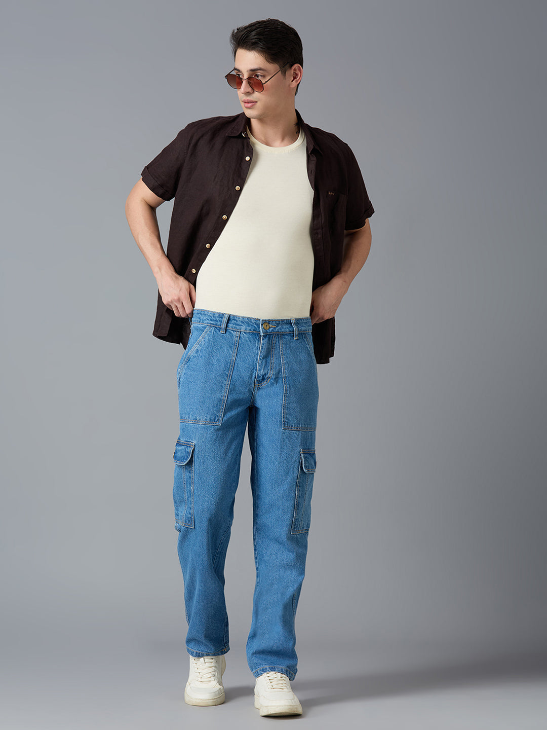 Model styling TCI Men's Blue Denim Cargo Pants with a White T-Shirt & Sneakers - Trendy Streetwear Look