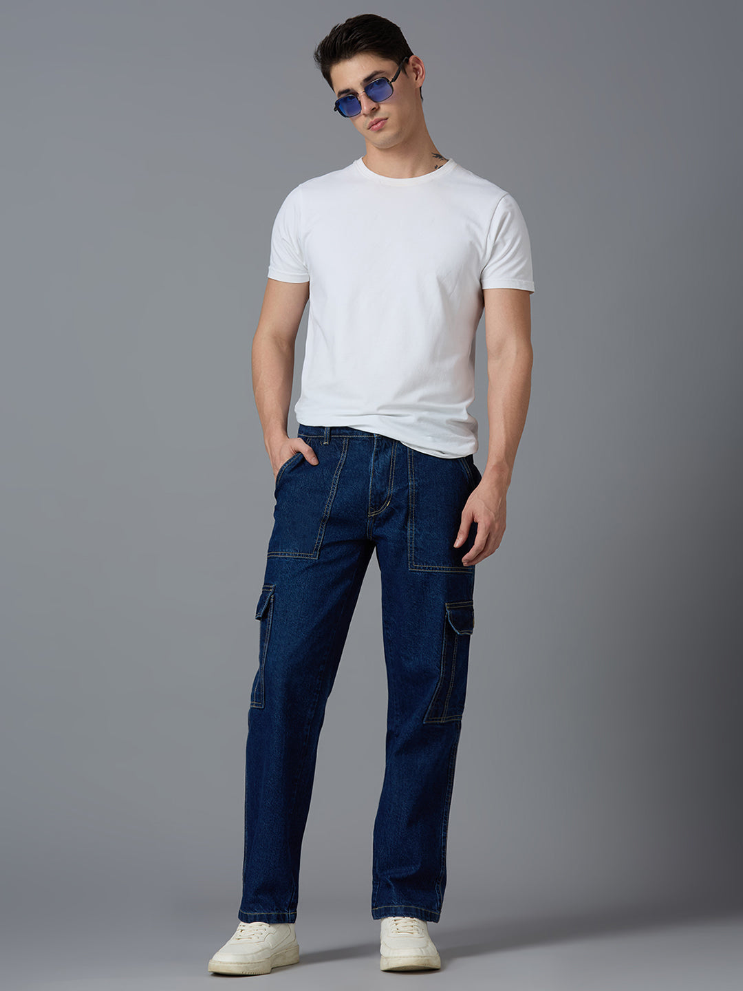 Model styling TCI Men's Dark Blue Denim Cargo Pants with a White T-Shirt & Sneakers - Trendy Streetwear Look