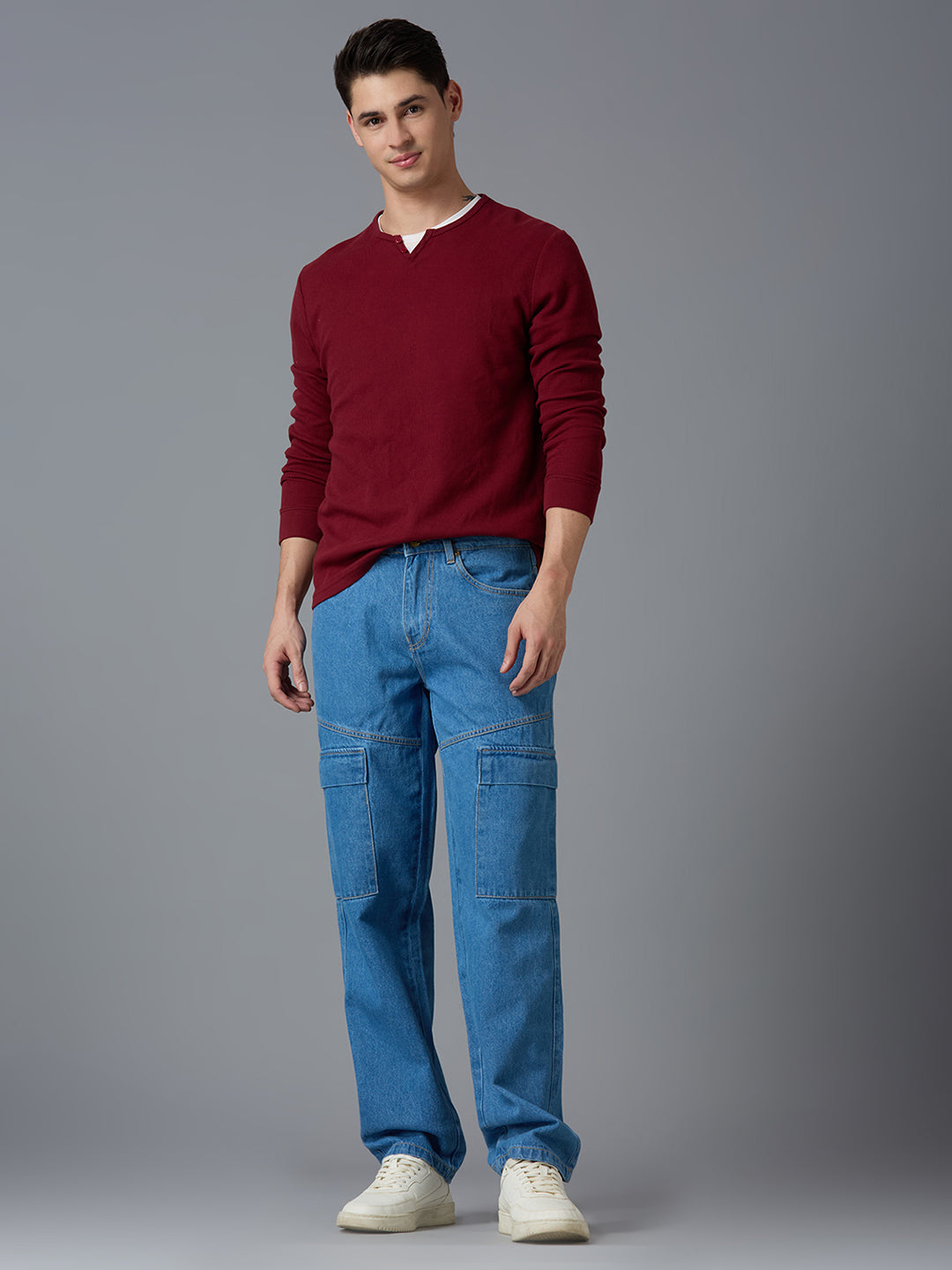 Model styling TCI Men's Wash Blue Denim Cargo Pants with a Red Pullover & Sneakers - Trendy Streetwear Look