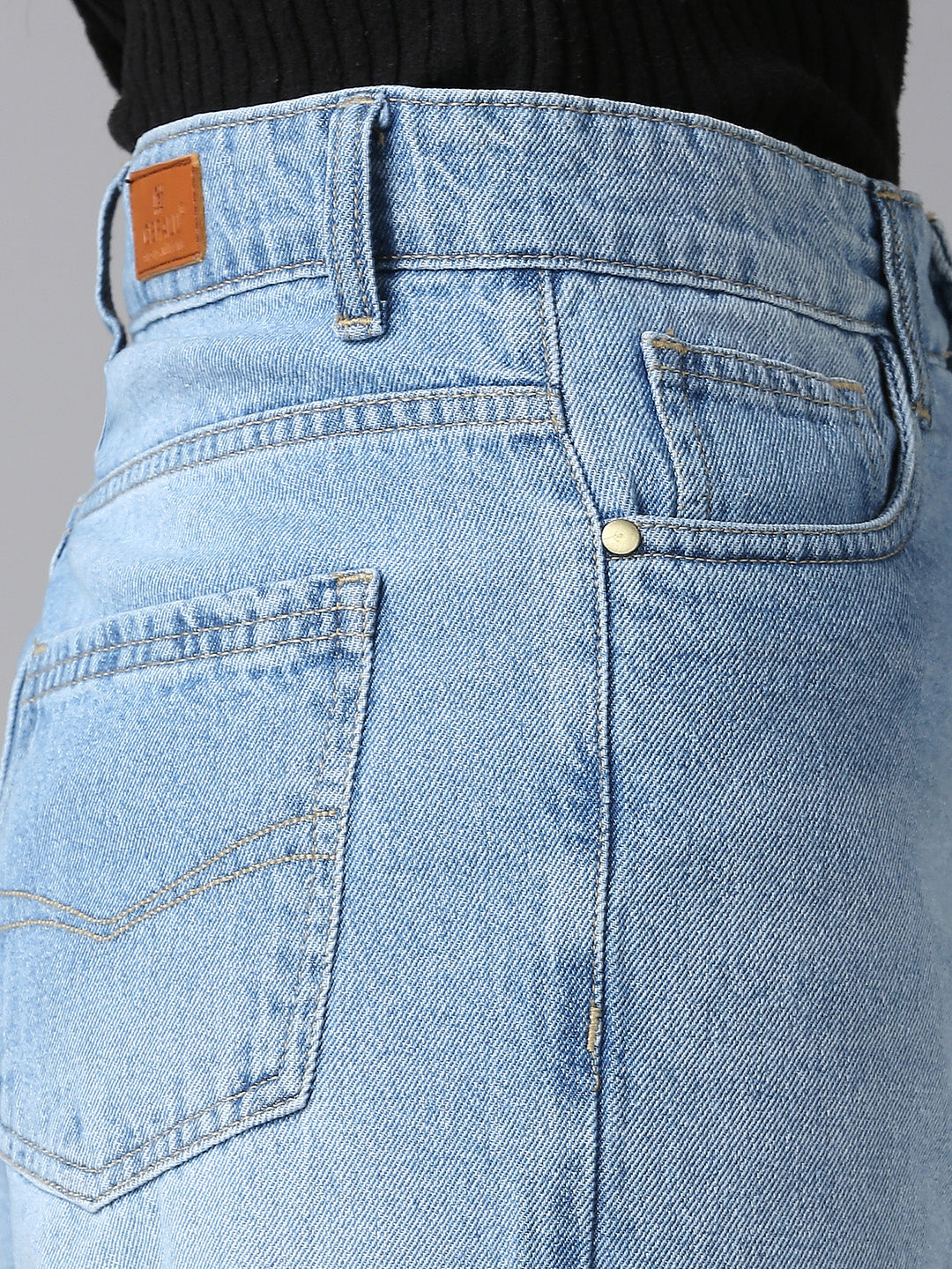 Close-up of CEFALU light wash wide-leg jeans highlighting the vertical seam details and high-waist fit.
