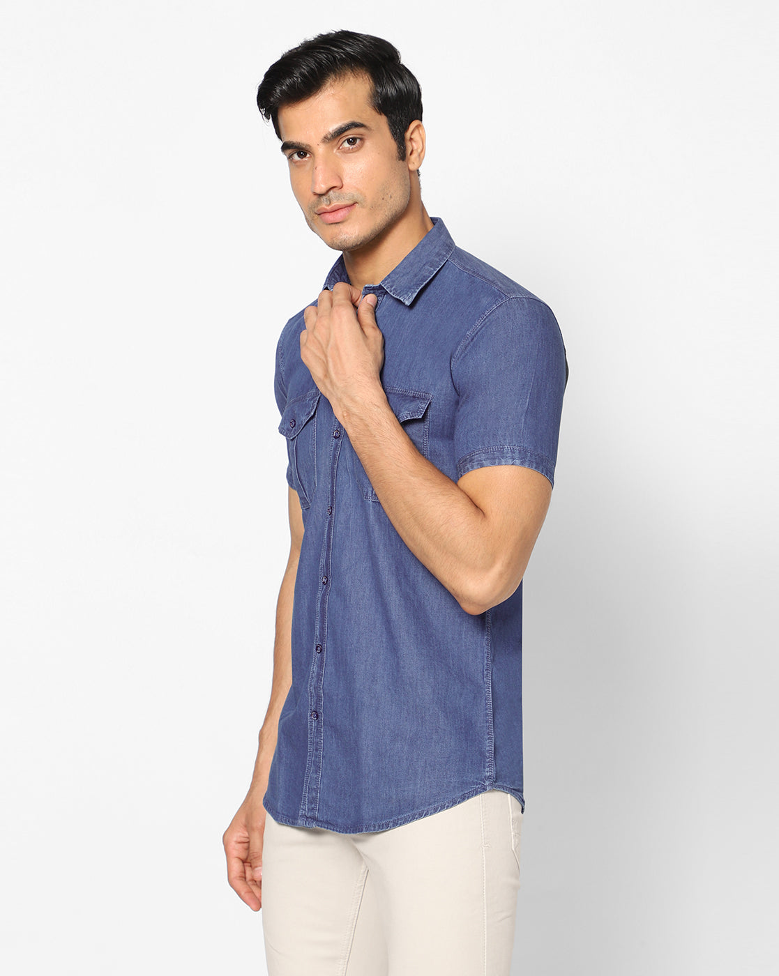 Side view of the TCI Men’s mid blue cotton denim shirt, highlighting the shirt’s half sleeves and overall fit.