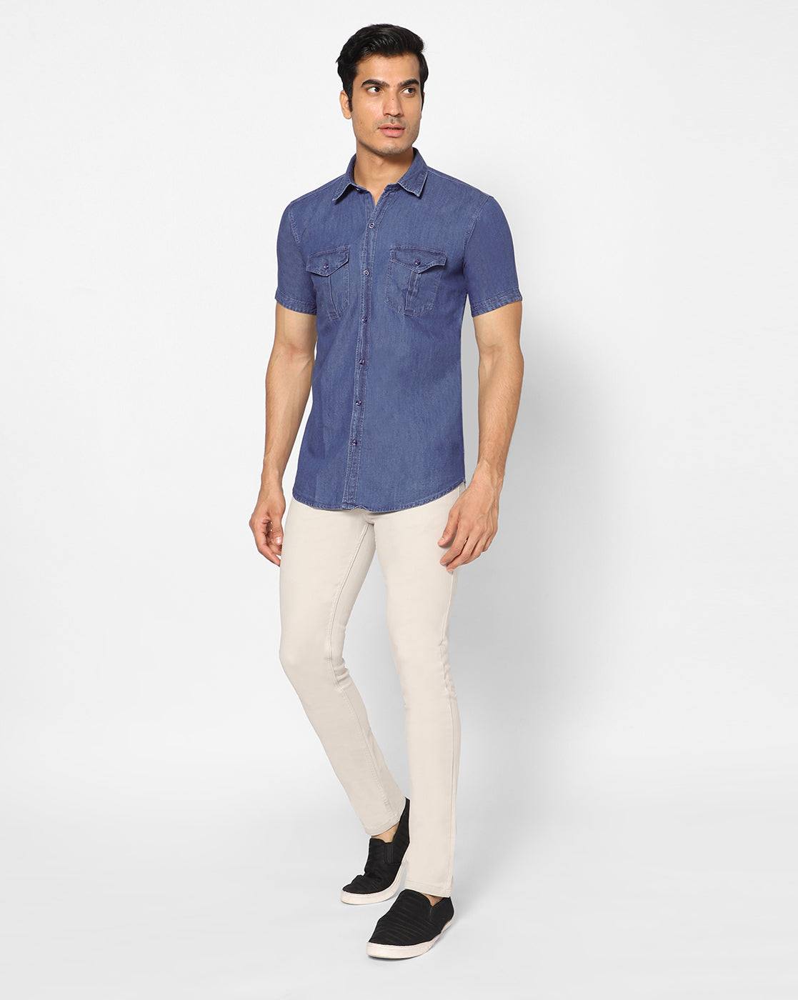 Full model view of a man wearing the TCI Men’s mid blue cotton denim shirt, showcasing the shirt’s fit and style in a casual setting.