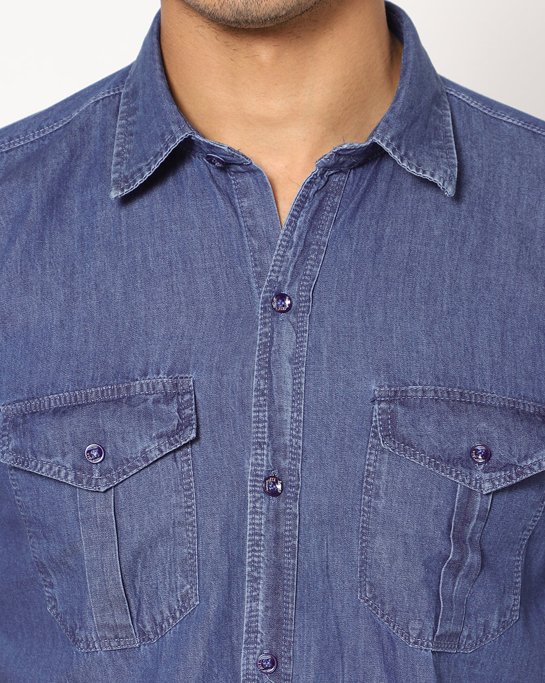 Close-up of the button-front and front chest pockets of the TCI Men’s mid blue cotton denim shirt.