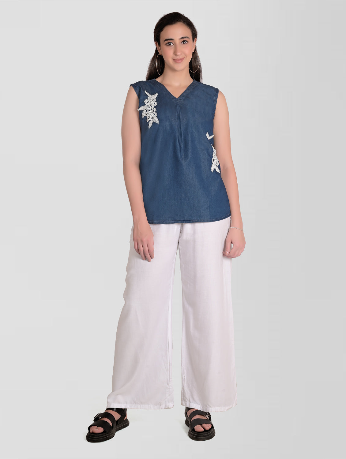 Model wearing Cefalu Women’s Blue Denim Top, featuring V-neck, sleeveless design, and patchwork detail.