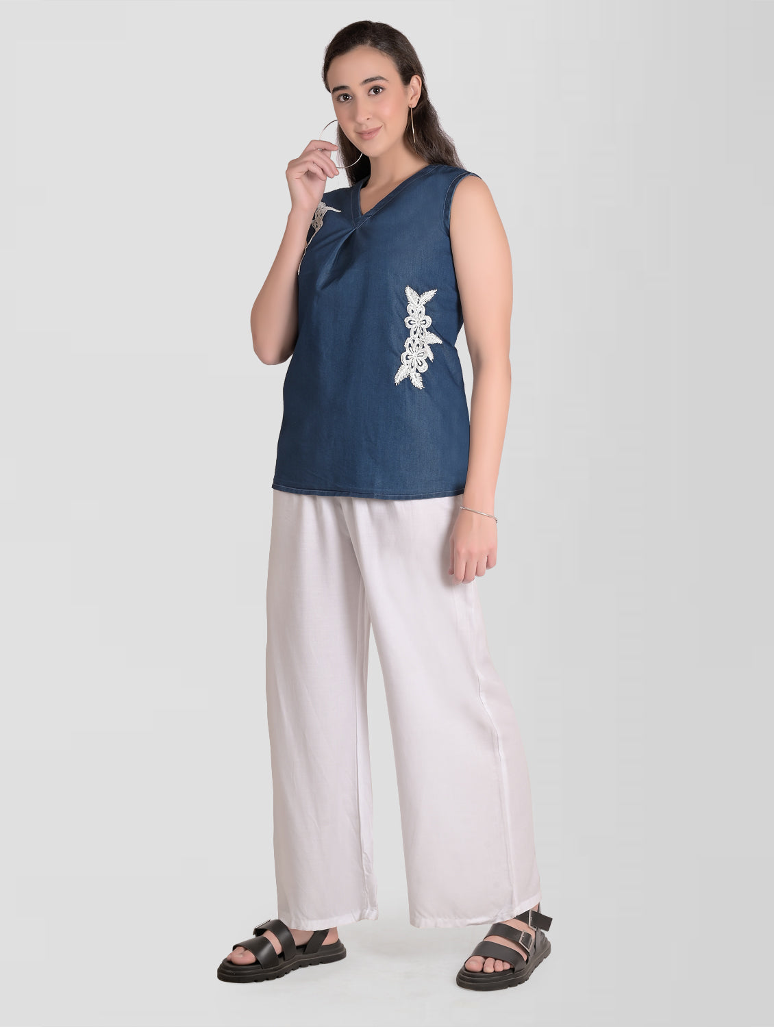 Model wearing Cefalu Women’s Blue Denim Top, featuring V-neck, sleeveless design, and patchwork detail.