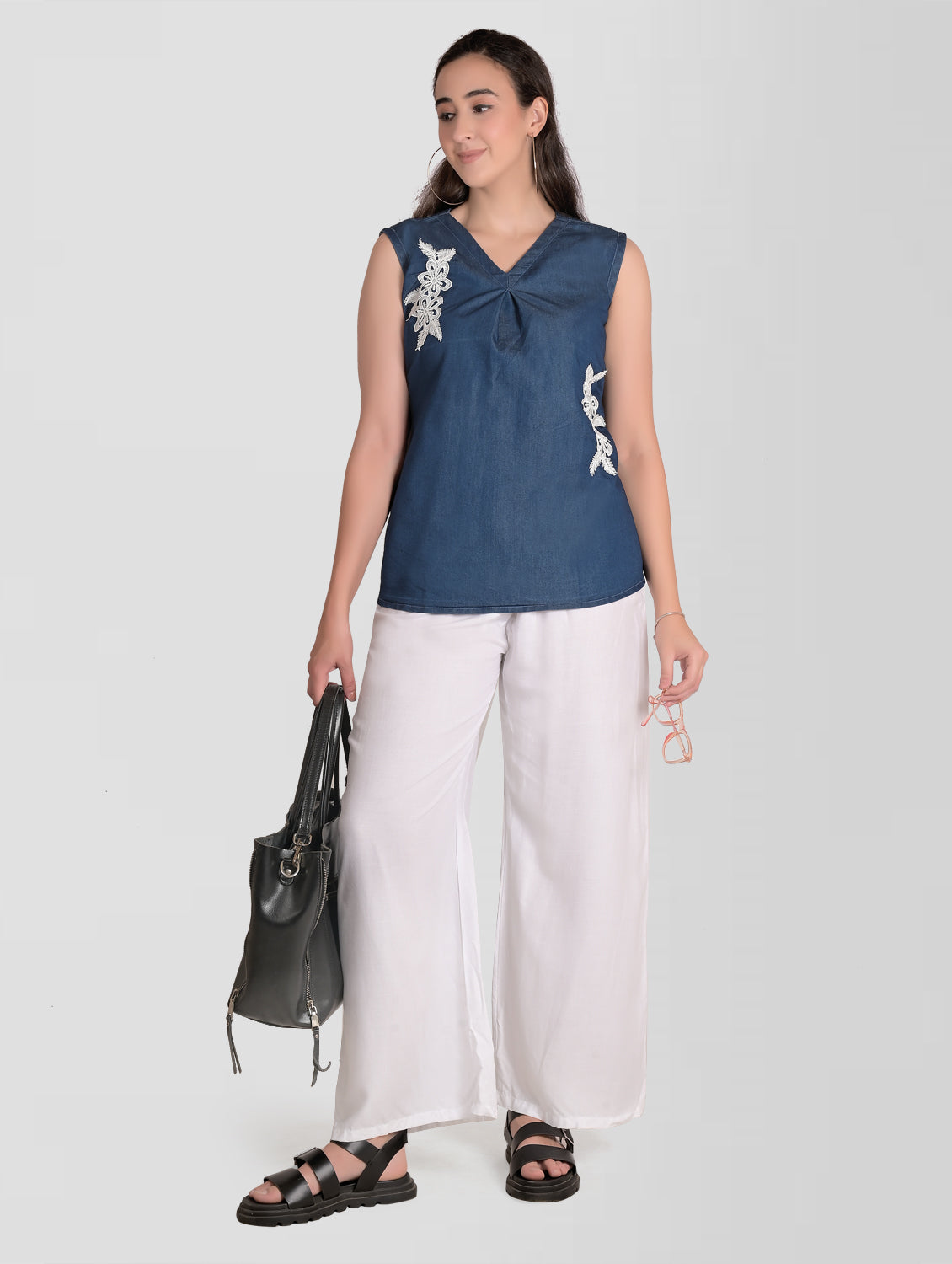 Model wearing Cefalu Women’s Blue Denim Top, featuring V-neck, sleeveless design, and patchwork detail.