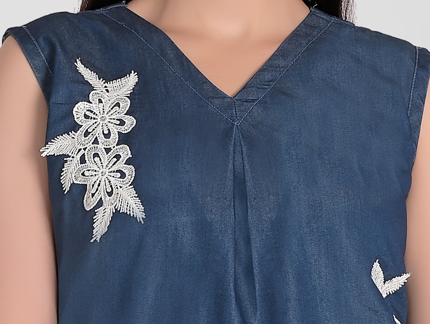 Close-up of V-neck and front patchwork detail on Cefalu Women’s Blue Denim Top.