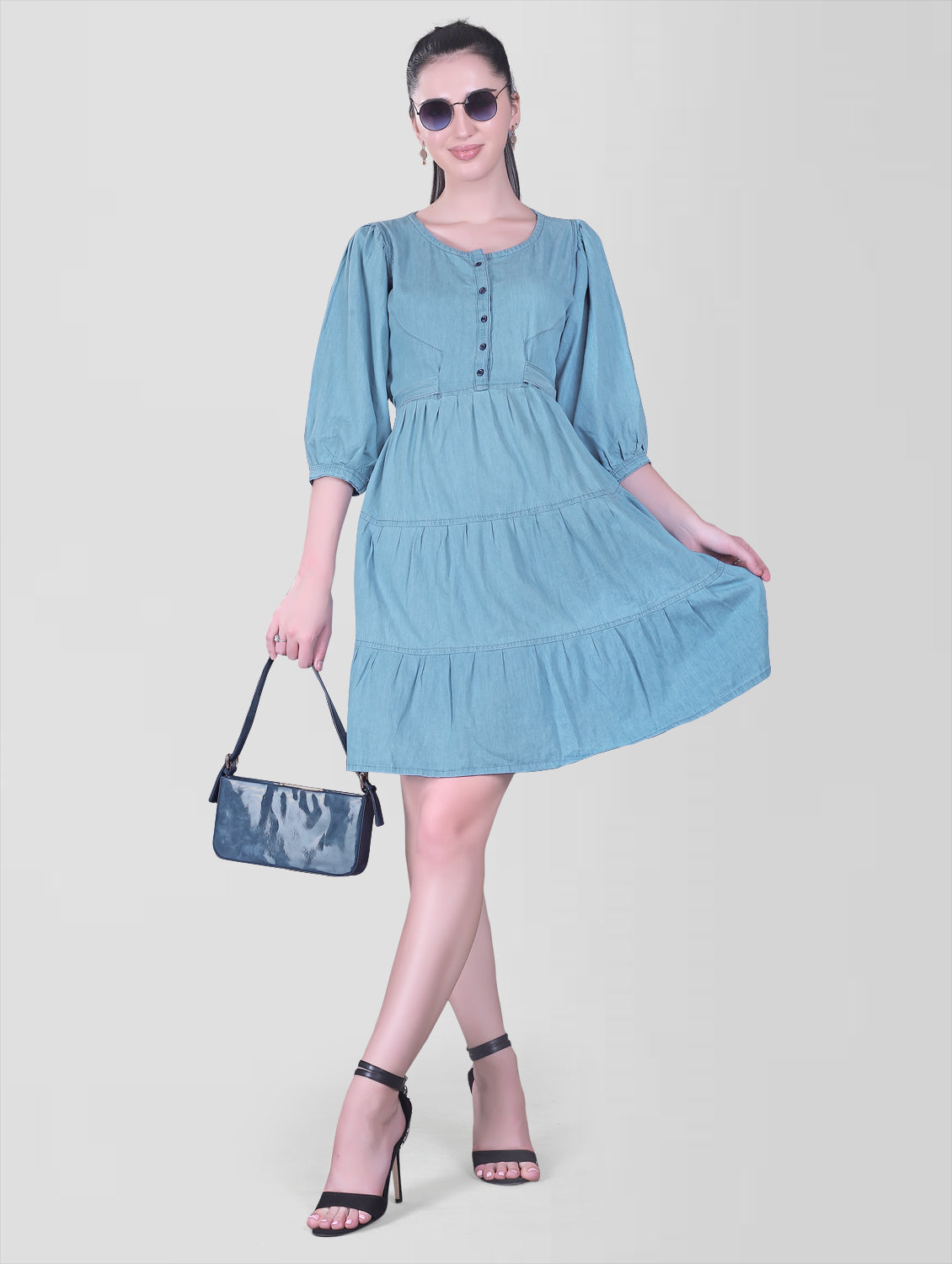 Model wearing Cefalu Women’s Light Blue Denim Dress, demonstrating the fit and flare style and 3/4 puff sleeves.