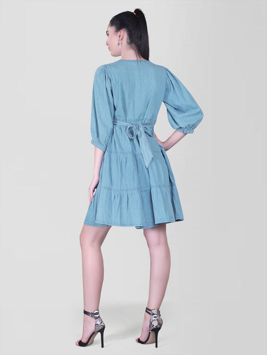 Back view of Cefalu Women’s Light Blue Denim Dress featuring belted waist and layered design.