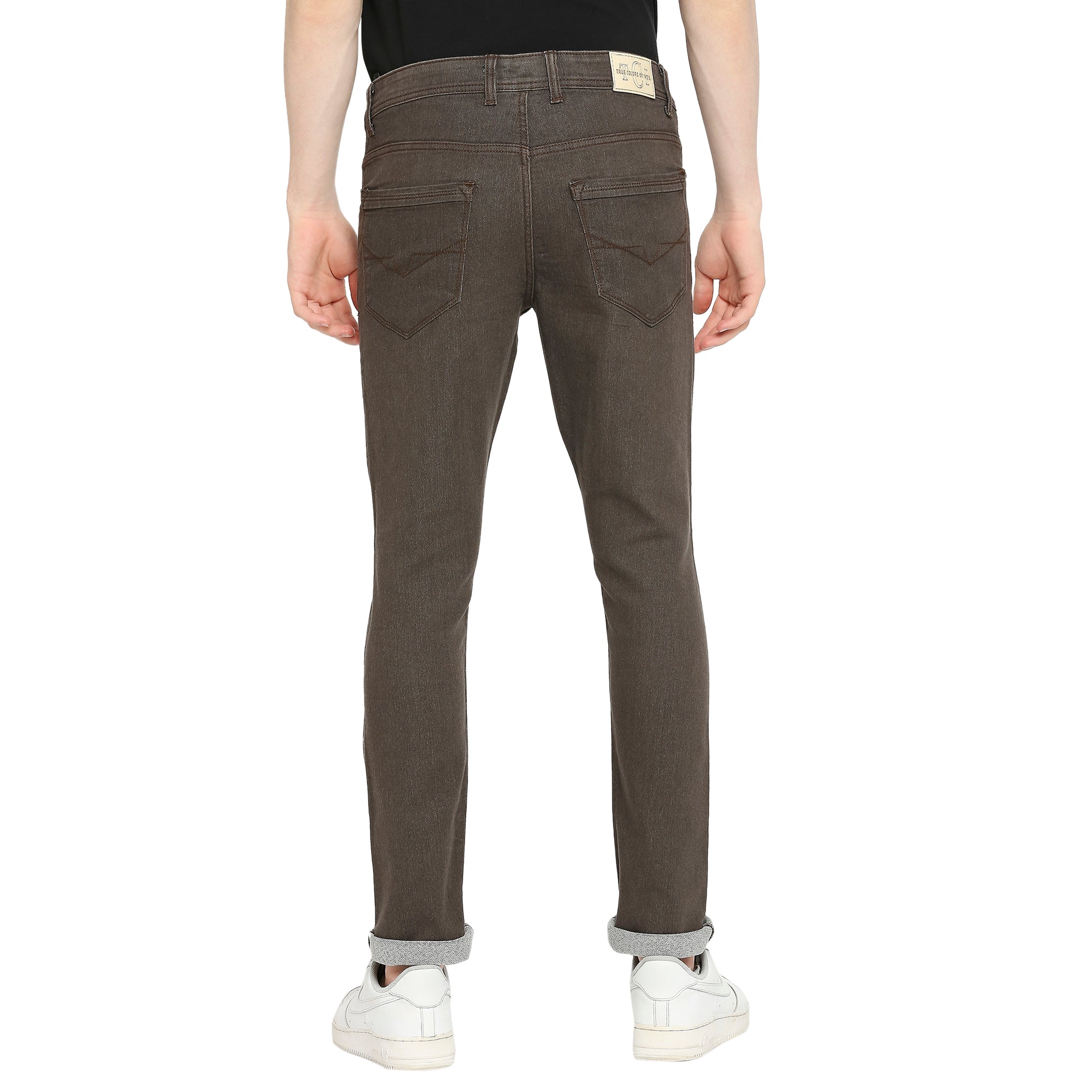 Back view of TCI Men’s Dark Brown Slim Fit Jeans highlighting the brand patch on the waistband, belt loops, and the overall fit. The image also shows the five-pocket design, including the coin pocket.