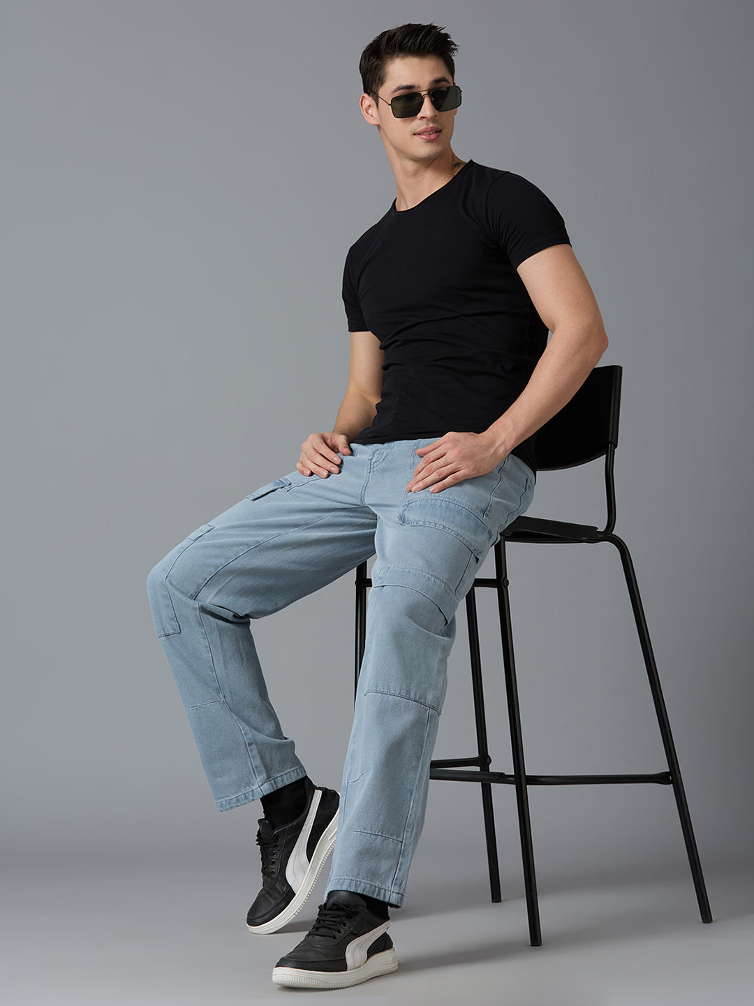 Model styling TCI Men's Grey Denim Cargo Pants with a Black T-Shirt & Sneakers - Trendy Streetwear Look