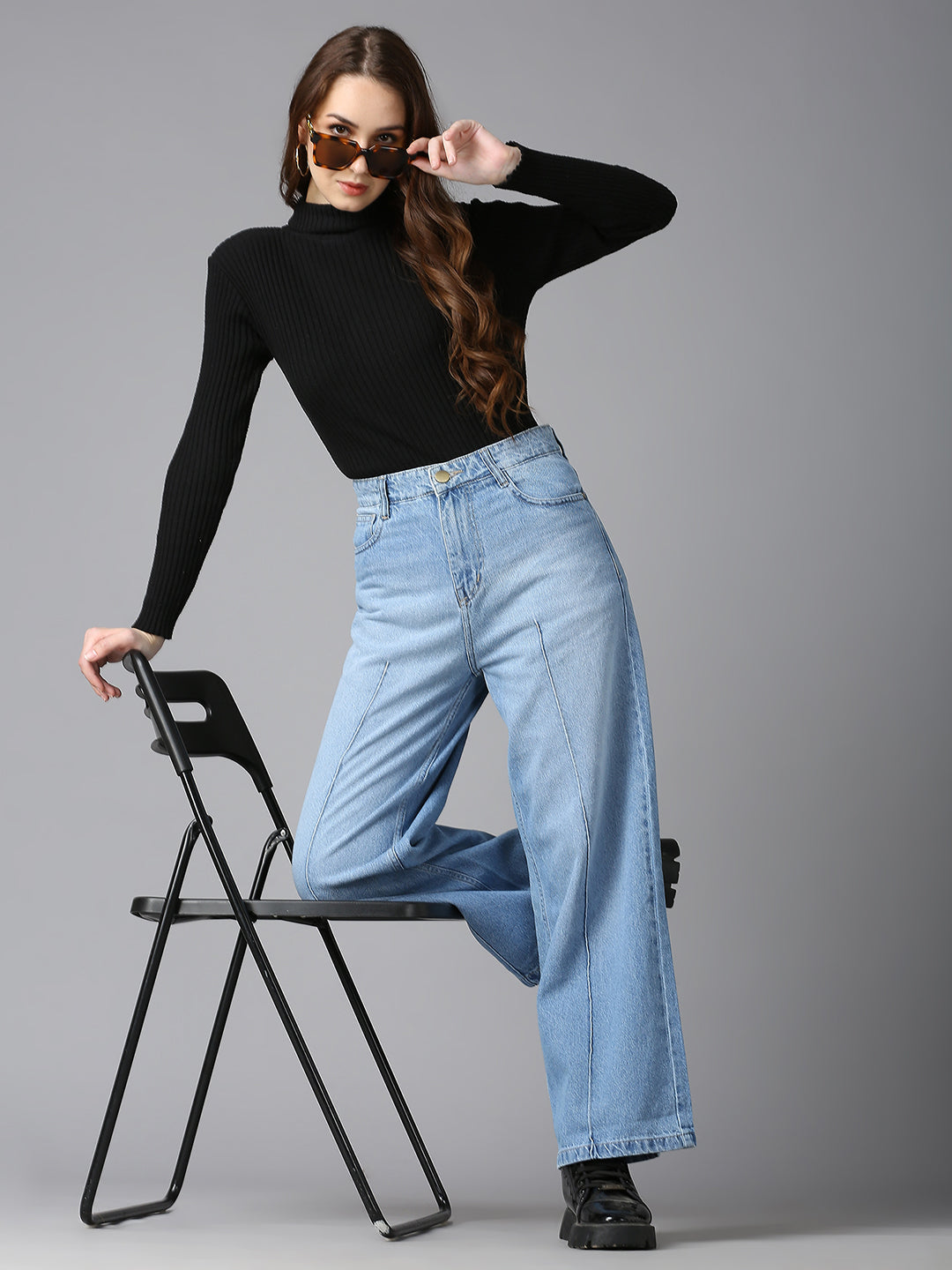 Model wearing CEFALU wide-leg light wash jeans paired with a black turtleneck and combat boots.