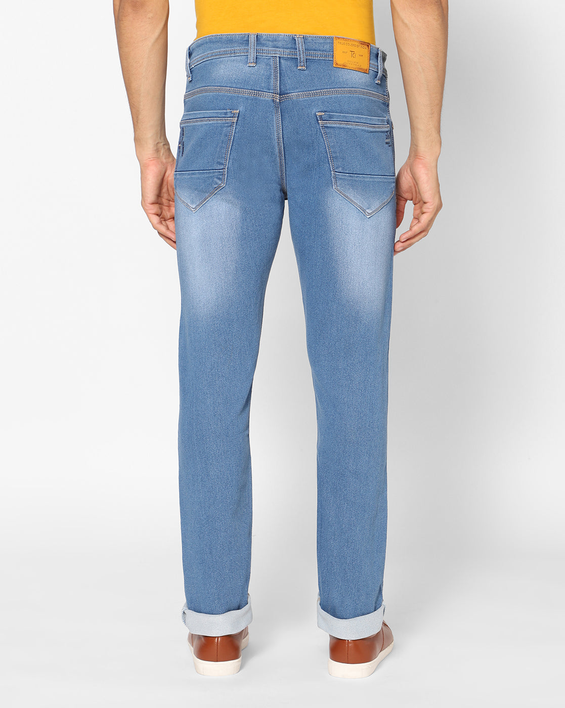 Back view of TCI Men’s Light Blue Stretchable Jeans, showcasing the functional back pockets and regular fit. The jeans are designed with a slightly distressed finish for a trendy look.