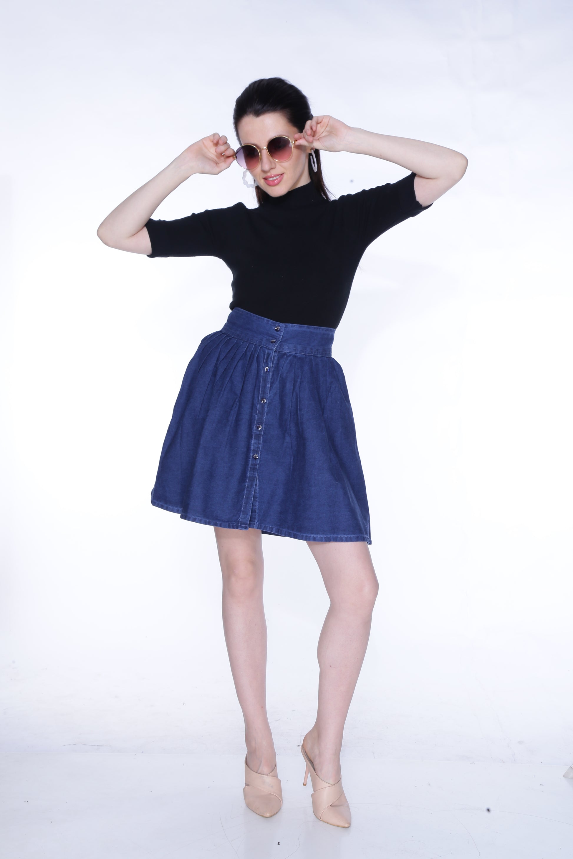 Full-length view of a model wearing Cefalu®️ Women’s Dark Blue Denim Mini Skirt, demonstrating its flattering fit and playful design.