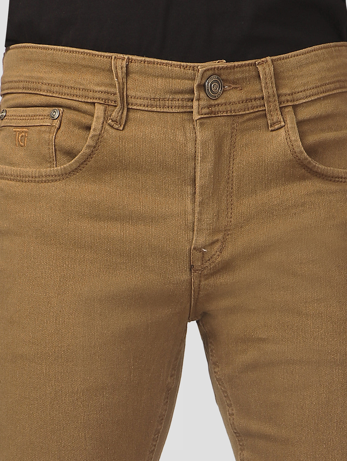 Close-up of TCI Men’s Golden Brown Slim Fit Jeans waistband, featuring belt loops and zip fly with button closure.